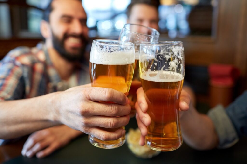 happy male friends drinking beer at bar or pub