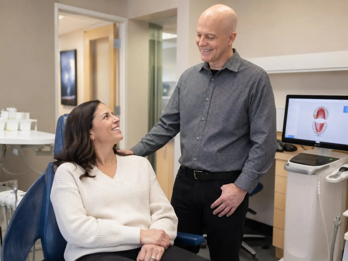 Dr. Michael DeWitt talking with a patient in an exam room at DeWitt Dental Associates in Cherry Creek