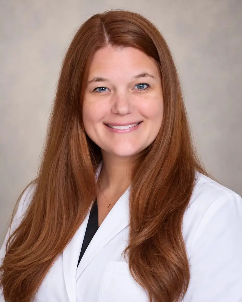 Professional portrait of Dr. Megan Telste, DDS, wearing a white clinical coat